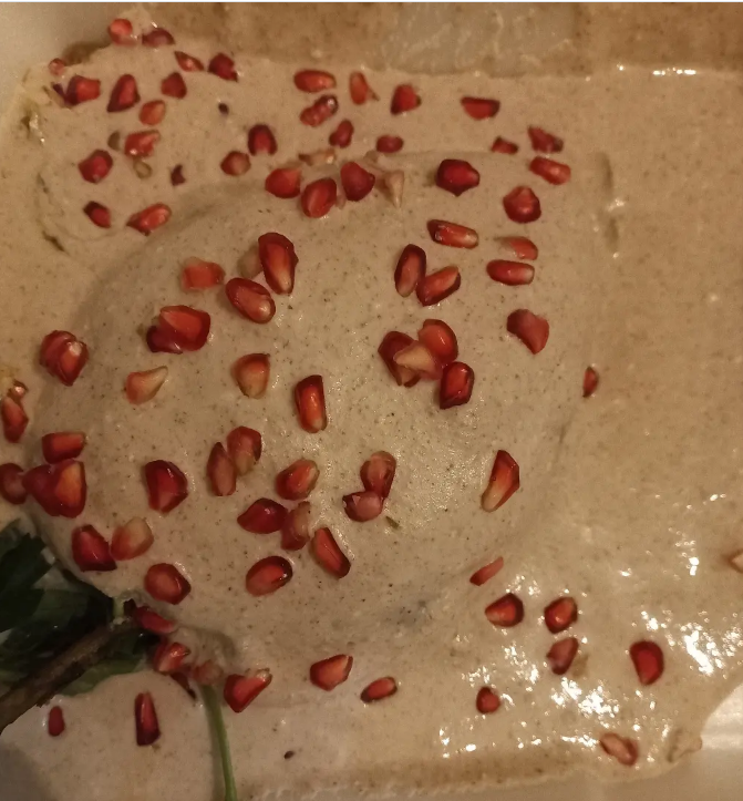 Chile en nogada cubierto con salsa de nuez, granada y perejil